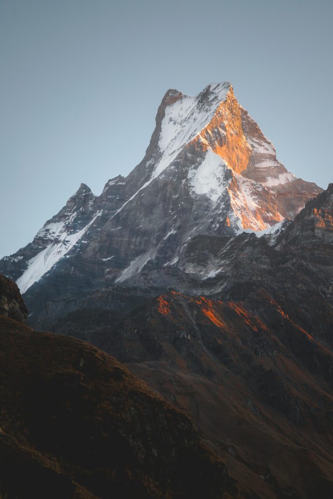 Capturing the majestic Machapuchare peak in Nepal, bathed in golden sunrise light.